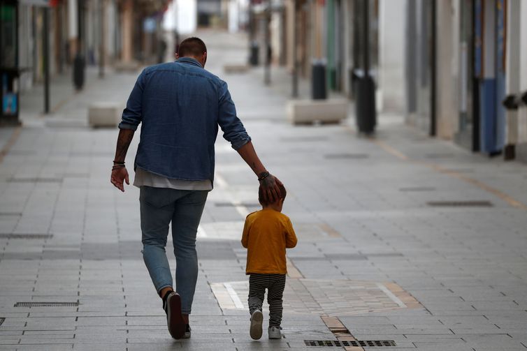 Pai e filho caminham juntos em meio a pandemia de covid-19 na Espanha.