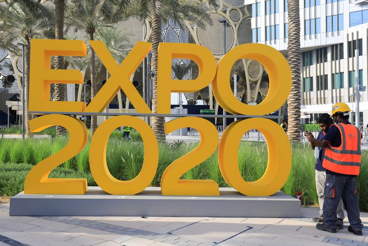 Workers are pictured next to the Expo 2020 logo ahead of the opening ceremony in Dubai