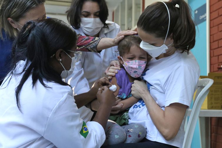A menina Clarice Moretti, 4 anos, toma sua primeira dose de vacina contra a Covid-19 no Centro Municipal de Saúde Píndaro de Carvalho Rodrigues, na Gávea, zona sul da cidade.