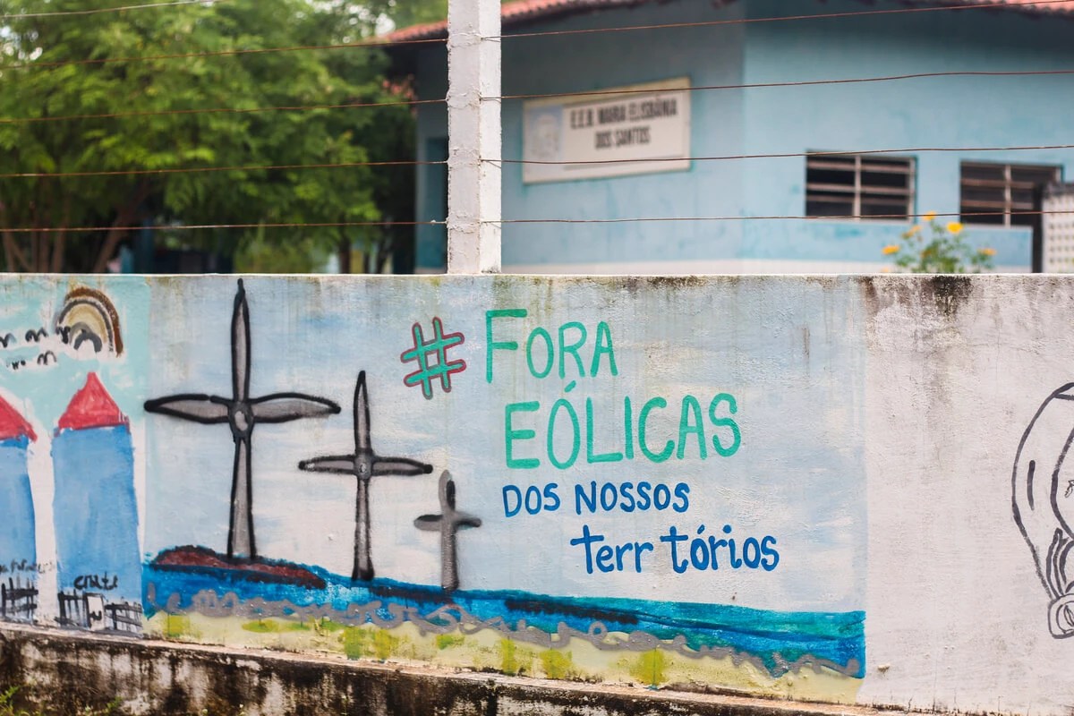 Desenho feito por moradores em muro com a frase "fora eólicas dos nossos territórios"