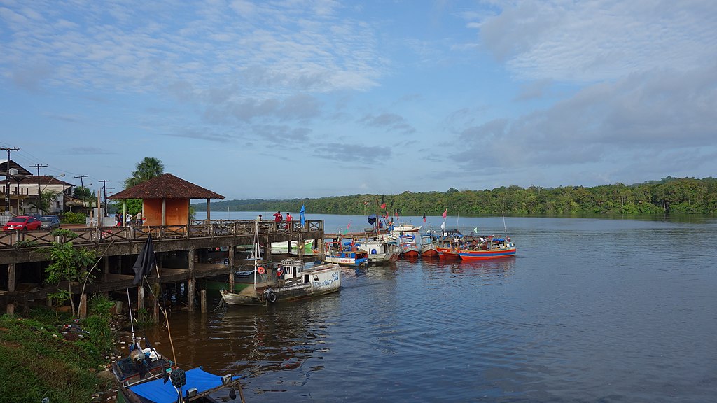 Margem da cidade de Oiapoque com casas de palafita e barcos no rio