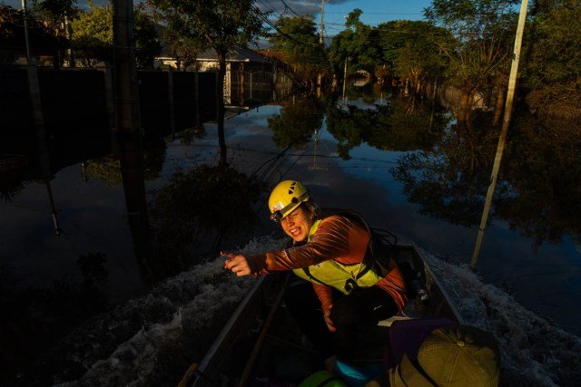 Uma voluntária de um grupo de resgate de animais em situação de desastre navega pelas ruas submersas de Canoas, Rio Grande do Sul, buscando cães e gatos que foram deixados para trás