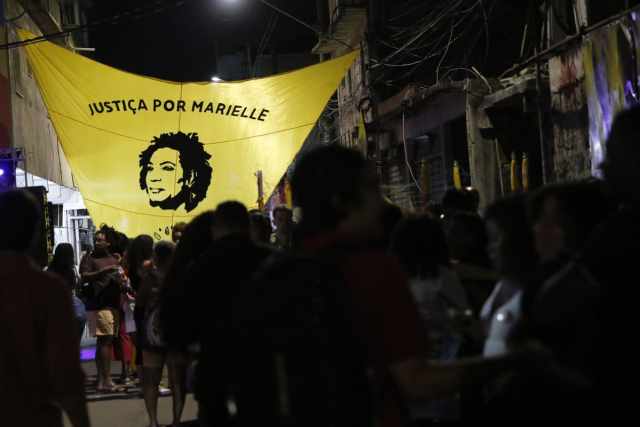 Moradores seguram faixa com foto da vereadora Marielle Franco